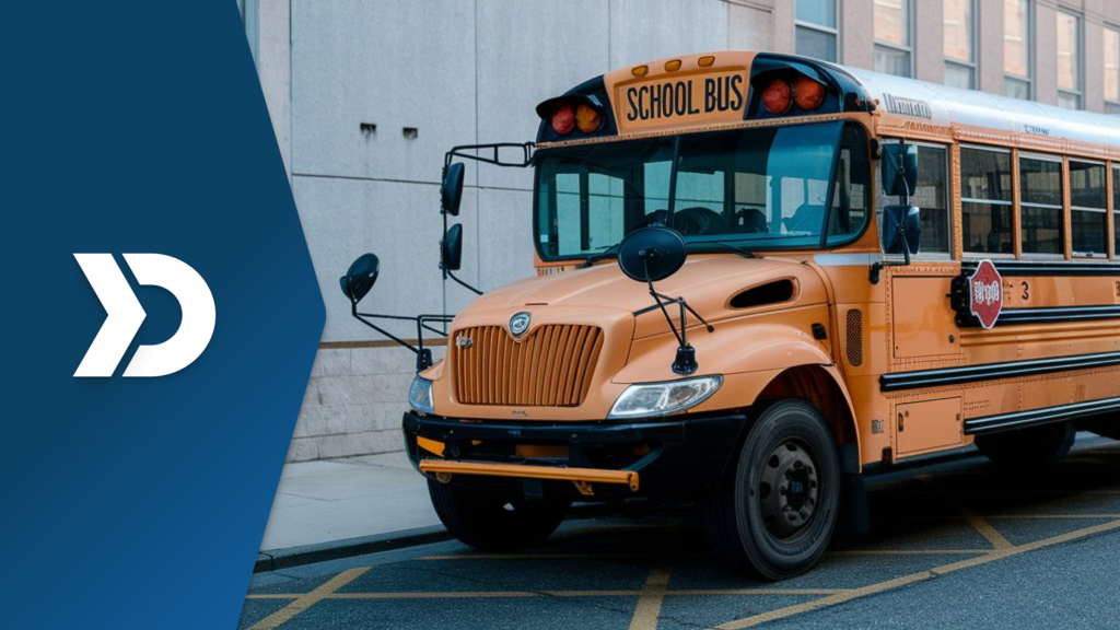 A yellow school bus parked near a school building, symbolizing the role of mobile telematics in improving school transportation safety and efficiency.