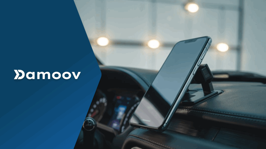 A smartphone mounted on a car’s steering wheel, symbolizing the role of mobile telematics in improving driving habits and promoting road safety.