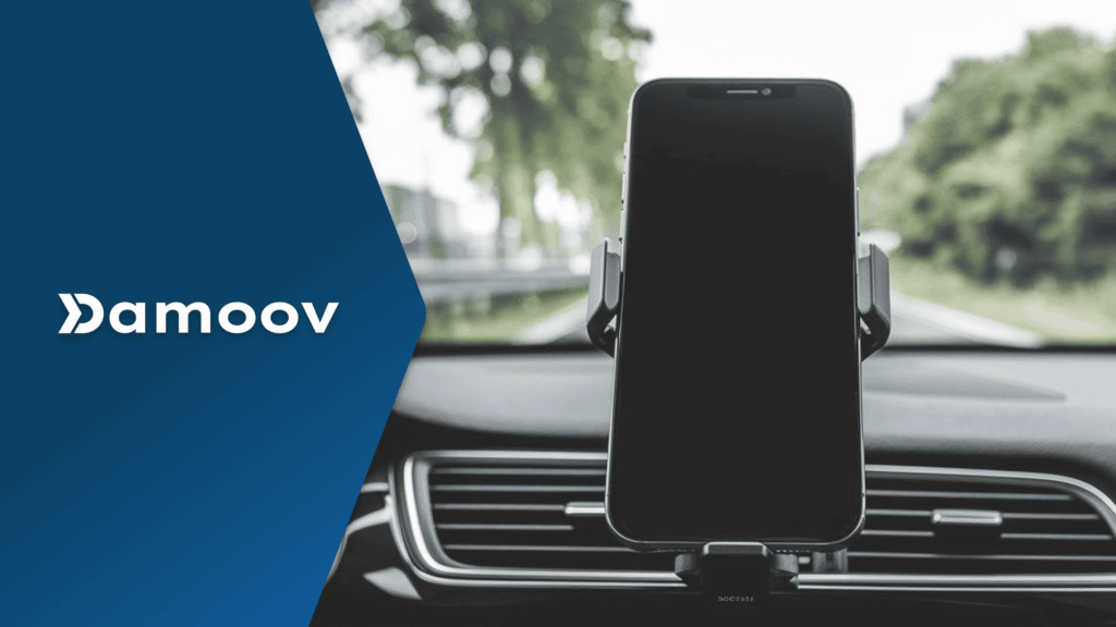 Smartphone mounted on car dashboard using Damoov’s mobile telematics for safe driving and real-time trip tracking